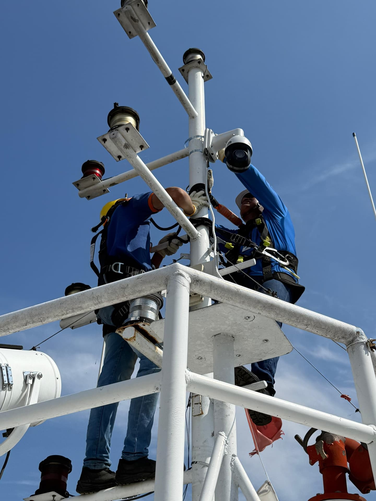 Técnicos instalando câmeras em mastro